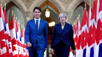 Prime Minister Justin Trudeau and British Prime Minister Theresa May walk in the Hall of Honour on Parliament Hill in Ottawa, Ontario, during a visit on Monday, Sept. 18, 2017.
