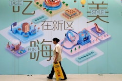 A cleaner walks by a vacant retail space wall displaying the directory map of a newly opened up-scale shopping mall at the Central Business District in Beijing, Tuesday, Sept. 19, 2017. A foreign business group appealed to China on Tuesday to move faster in carrying out promises to open its state-dominated economy and warned that inaction might fuel a backlash against free trade. Beijing faces mounting complaints from Washington and Europe about barriers in industries from finance to medical equipment while its own competitors have largely unfettered access to foreign markets.