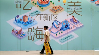 A cleaner walks by a vacant retail space wall displaying the directory map of a newly opened up-scale shopping mall at the Central Business District in Beijing, Tuesday, Sept. 19, 2017. A foreign business group appealed to China on Tuesday to move faster in carrying out promises to open its state-dominated economy and warned that inaction might fuel a backlash against free trade. Beijing faces mounting complaints from Washington and Europe about barriers in industries from finance to medical equipment while its own competitors have largely unfettered access to foreign markets.
