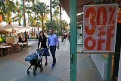 In this Wednesday, April 26, 2017, photo, pedestrians walk past a store on Miami Beach, Florida's Lincoln Road. American consumers feel a bit less confident in September 2017, their spirits pulled down by Hurricanes Harvey and Irma, according to consumer confidence index information released Tuesday, Sept. 26, 2017, by the Conference Board.