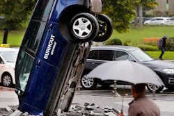A Volkswagen Touareg stands upside down in front of the fair ground of the IAA Motor Show in Frankfurt, Germany, Wednesday, Sept. 13, 2017. The environmental organization Greenpeace installed the car the day before to protest against the car industry. From frighteningly fast hypercars to new electric SUVs, the Frankfurt auto show is a major event for car lovers wanting to get a glimpse of the future.