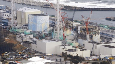 In this March 11, 2012, file photo, three melted reactors, from left, Unit 1, Unit 2 and Unit 3, are seen at Fukushima Dai-ichi nuclear power plant in Okuma, Fukushima prefecture, Japan. Japan's government approved on Tuesday, Sept. 26, 2017 a revision to the decommissioning plan for the Fukushima nuclear plant, delaying by two more years the removal of radioactive fuel rods in two of the three reactors damaged in the 2011 disaster. It still plans for melted fuel to be removed starting in 2021, but the lack of details about the duration raises doubts if the cleanup can be completed within 40 years.