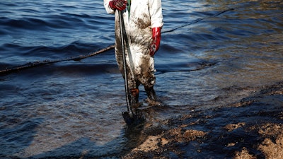 A workers cleans a beach of an oil spillage at Faliro suburb, near Athens.