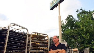 In this Sept. 2, 2017 photo, Bobby Jucker, owner of Three Brothers Bakery, cleans up storm damage at his bakery in Houston. In 2008, Hurricane Ike tore the roof off his business. Now he estimates he's facing $1 million in damage and lost revenue from Hurricane Harvey, the fifth time a storm has put his bakery out commission.