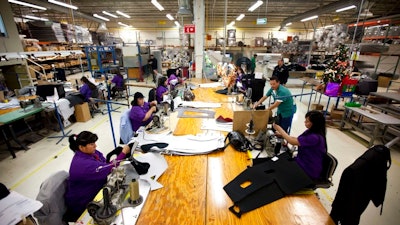 In this Friday, Dec.27, 2013 file photo, workers manufacture car dash mats at a maquiladora belonging to the TECMA group in Ciudad Juarez, Mexico. In Mexico where the auto industry has boomed under the North American Free Trade Agreement, the industry has created a class of workers who are barely getting by. Many can’t afford even a used car, taking home as little as $50 per week after deductions for mortgages and cafeteria meals.