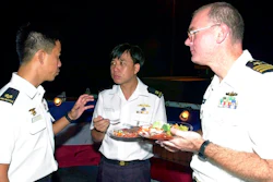 This July 4, 2001, file photo provided by the U.S. Department of Defense shows U.S. Navy Commander Dave Kapaun, right, with Republic of Singapore Navy Major Danny Tan, left, and Republic of Singapore Major H .C. Lim at a reception on board the U.S. Navy dock landing ship USS Rushmore during the seventh annual Cooperation Afloat Readiness and Training (CARAT) Exercise. Retired U.S. Navy Commander Kapaun,who pleaded guilty to lying about his relationship with a Malaysian defense contractor nicknamed 'Fat Leonard' is facing sentencing.