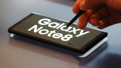 A man demonstrates Samsung Electronics' Galaxy Note 8 during a media day in Seoul, South Korea, Tuesday, Sept. 12, 2017. Samsung Electronics says its aims to launch a foldable smartphone next year under its Galaxy Note brand. Koh Dong-jin, president of mobile business at Samsung Electronics, said Tuesday that the company is currently setting its eyes on 2018 to release a smartphone with a bendable display but there are several hurdles it has to overcome.