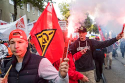 Demonstrators hold Bengal flare during a protest in Bochum, western Germany, Friday, Sept. 22, 2017. Thousands of steelworkers have gathered in a protest over the planned merger of the European steel operations of Thyssenkrupp and Tata Steel, which is expected to cost up to 4,000 jobs.