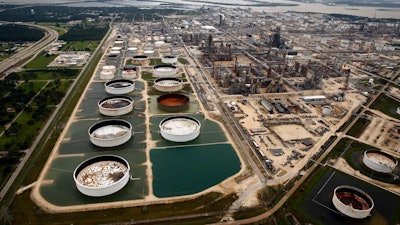 In this Wednesday, Aug. 30, 2017 file photo, large storage tanks situated in retention ponds are surrounded by rainwater left behind by Tropical Storm Harvey at ExxonMobil's refinery in Baytown, Texas. Companies have reported that roughly two dozen storage tanks holding crude oil, gasoline and other fuels collapsed or otherwise failed during Harvey, spilling a combined 140,000 gallons of fuel, according to an Associated Press analysis of state and federal accident databases. Federal rules require companies to be prepared for spills, but don't require them to take any specific measures to secure the massive fuel storage tanks at refineries and oil production sites that are prone to float and break during floods.