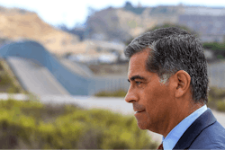 With the U.S Mexican border in the background, California State Attorney General Xavier Becerra talks to members of the media after he announced that he'd be filing a lawsuit against the Trump administration over the building of a wall on the U.S. border with Mexico, during a news conference at Border Field State Park in San Diego on Wednesday, Sept. 20, 2017.