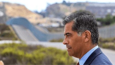 With the U.S Mexican border in the background, California State Attorney General Xavier Becerra talks to members of the media after he announced that he'd be filing a lawsuit against the Trump administration over the building of a wall on the U.S. border with Mexico, during a news conference at Border Field State Park in San Diego on Wednesday, Sept. 20, 2017.