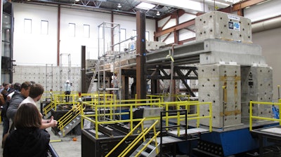 Researchers and invited dignitaries watch gathered at the University of Nevada, Reno's new Earthquake Engineering Laboratory in Reno, Nev., on Wednesday, Sept. 20, 2017, before a series of tests on new bridge designs intended to better withstand violent temblors. Scientists say the 100-ton, 70-foot-long concrete bridge subjected to violent motions on a giant ''shake table'' held up better than expected using new innovations to connect prefabricated pieces with ultra-high performance concrete and could prove pivotal in earthquake-prone places like Mexico and the western U.S.