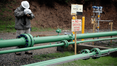 In this Jan. 12, 2017 file photo, an employee uses an infrared camera to detect a gas leak at the Southern California Gas Company's Aliso Canyon storage facility near the Porter Ranch neighborhood of Los Angeles. A third of the wells that inject natural gas into underground storage were taken out of service weeks after a troubled Los Angeles facility restarted following a massive blowout. Southern California Gas Co. said Monday, Sept. 11, that it notified state regulators in August that 13 of the 39 wells at Aliso Canyon were shut down after detecting a pressure buildup.