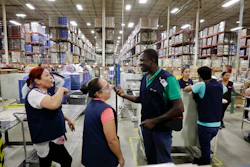 In this June 6, 2017 photo, Evens Presendeaux of Haiti speaks with coworkers on the floor of a factory in Tijuana, Mexico. Presendeaux is among about 4,000 Haitians to establish roots in Mexico's northwest corner after the United States abruptly closed its doors late last year. The Mexican government has welcomed them, and they are already having an outsize economic and cultural impact.