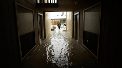 In this Aug. 29, 2017 file photo, Steven Hathaway searches for people to help in an apartment complex in Kingwood, Texas. Authorities say standing water will contain untreated sewage, along with spilled fuel and toxic waste. They’re urging residents to stay out of it when possible.