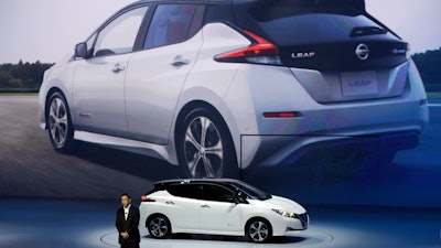 In this Wednesday, Sept. 6, 2017 file photo, Nissan President and CEO Hiroto Saikawa unveils its new Leaf electric vehicle during the world premiere in Chiba, Japan. The Renault-Nissan alliance is ramping up electric car production, vowing 12 new models by 2022 and to make electric cars 30 percent of its overall production.