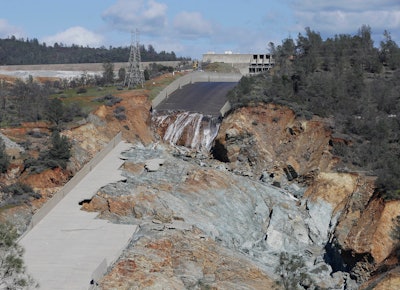 In this Feb. 28, 2017, file photo, a small flow of water goes down Oroville Dam's crippled spillway in Oroville, Calif. A towering spillway at the nation's tallest dam was crumbling and tens of thousands of people were fleeing for their lives, but as darkness fell state managers suddenly discovered the unfolding crisis in Northern California was about to get even worse: They couldn't see. For years federal regulators had urged keepers at the state-run Oroville Dam to install more cameras and other monitors to warn and guide them in just such an emergency.