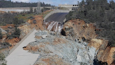 In this Feb. 28, 2017, file photo, a small flow of water goes down Oroville Dam's crippled spillway in Oroville, Calif. A towering spillway at the nation's tallest dam was crumbling and tens of thousands of people were fleeing for their lives, but as darkness fell state managers suddenly discovered the unfolding crisis in Northern California was about to get even worse: They couldn't see. For years federal regulators had urged keepers at the state-run Oroville Dam to install more cameras and other monitors to warn and guide them in just such an emergency.
