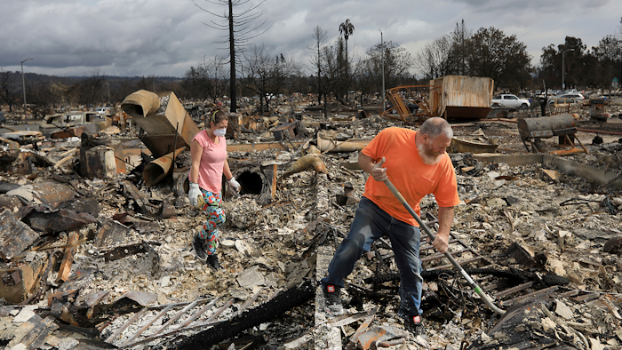 Sarah Boryszewski is helped by her father Gerald Peete as they dig for belongings in the remains of Boryszewski's home in Coffey Park, Friday Oct. 20, 2017 in Santa Rosa, Calif. Northern California residents who fled a wildfire in the dead of night with only minutes to spare returned to their neighborhoods Friday for the first time in nearly two weeks to see if anything was standing.