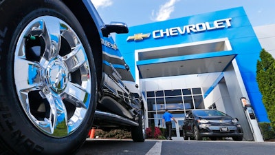 This Wednesday, April 26, 2017, photo shows the logo on the wheel of an SUV in front of a Chevrolet dealership in Richmond, Va. General Motors and Ford each posted strong U.S. sales in September 2017, confirming predictions that the industry could rebound for the month.