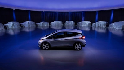 This photo provided by General Motors Co. shows a Chevrolet Bolt, surrounded by nine electric and fuel cell vehicles covered by tarps. On Monday, Oct. 2, 2017, GM announced the company will produce two new electric vehicles on the Bolt underpinnings in the next 18 months and 20 electric and hydrogen fuel cell vehicles by 2023.