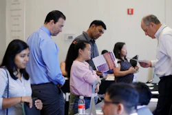 In this Thursday, Aug. 24, 2017, photo, Phil Wiggett, right, a recruiter with the Silicon Valley Community Foundation, looks at a resume during a job fair in San Jose, Calif. On Friday, Oct. 6, 2017, the U.S. government issues the September jobs report.