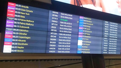 Monarch Airlines passengers are directed to the airline desk at London's Gatwick Airport, Monday, Oct. 2, 2017. Troubled British carrier Monarch Airlines has suspended flights after failing to resolve its financial woes. The airline, the country's fifth largest, stopped trading on Monday, warning travelers it had ceased operations.