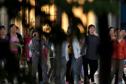 In this Aug. 31, 2017, photo, North Korean workers walk in a group to dormitories in the compound of the seafood processing factory Hunchun Pagoda in the city of Hunchun in northeastern China's Jilin province. Roughly 3,000 North Koreans are believed to work in Hunchun, a far northeast Chinese industrial hub just a few miles from the borders of both North Korea and Russia. The workers are paid a fraction of their salaries, while the rest - as much as 70 percent - is taken by North Korea’s government.