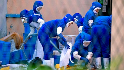 In this Sept. 4, 2017, photo, workers at a seafood processing plant where North Korean workers are distinguished from the Chinese workers by blue overalls wash up after work in the city of Hunchun, in northeastern China's Jilin province. At a time when North Korea faces sanctions on many exports, it sends of tens of thousands of workers worldwide bringing in revenue estimated at anywhere from $200 million to $500 million. That could account for a sizable portion of its nuclear weapons and missile programs, which South Korea says has cost well over $1 billion.