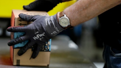 An employee packages a product at the Amazon Fulfillment center in Robbinsville Township, N.J. On Wednesday, Oct. 25, 2017, Amazon said that it will launch a new service in November that will let delivery people inside homes to drop off packages.