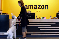 In this Wednesday, Oct. 11, 2017, photo, an Amazon employee gives her dog a biscuit as the pair head into a company building, where dogs are welcome, in Seattle. Whichever city lands Amazon’s second headquarters, some people in Seattle, it’s original hometown, say there are downsides to having the tech giant in the neighborhood.