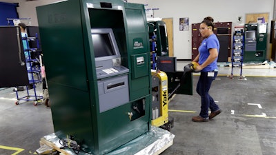 In this Wednesday, Aug. 30, 2017, photo, employee Maria Edney moves an automated teller machine during the manufacturing process at Diebold Nixdorf in Greensboro, N.C. On Monday, Oct. 2, 2017, the Institute for Supply Management releases its service sector index for September.