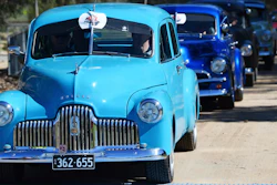 In this Oct. 15, 2017, historic Holden cars parade through the streets of Adelaide, Australia. The Australian auto manufacturing era ends after more than 90 years on Friday, Oct. 20, 2017 when General Motors Co.'s last Holden sedan rolls off the production line in the industrial city of Adelaide. The nation has already begun mourning the demise of a home-grown industry in an increasing crowded and changing global car market.