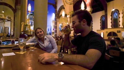 Jesse Hulien, right, drinks a beer as Molly Hartman, left, looks on, at the Church Brew Works, a former church renovated into a brewery, in Pittsburgh.