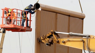 Crews work on a border wall prototype near the border with Tijuana, Mexico, Thursday, Oct. 19, 2017, in San Diego. Companies are nearing an Oct. 26 deadline to finish building eight prototypes of President Donald Trump's proposed border wall with Mexico.
