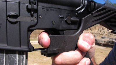 In this Oct. 4, 2017, file photo, shooting instructor Frankie McRae demonstrates the grip on an AR-15 rifle fitted with a 'bump stock' at his 37 PSR Gun Club in Bunnlevel, N.C. The Brady Center to Prevent Gun Violence filed the lawsuit on Friday, Oct. 6, 2017, against the makers and sellers of “bump stocks,” which use the recoil of a semiautomatic rifle to let the finger 'bump' the trigger, allowing the weapon to fire continuously. The devices were used by Stephen Paddock when he opened fire on a country music festival in Las Vegas, killing dozens of people.