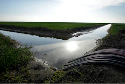 In this Feb. 25, 2016 file photo, water flows through an irrigation canal to crops near Lemoore, Calif. A spokesman for the U.S. Department of the Interior said Wednesday, Oct. 25, 2017, that the Trump administration will not support a giant California water project sought by Gov. Jerry Brown.