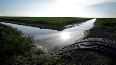 In this Feb. 25, 2016 file photo, water flows through an irrigation canal to crops near Lemoore, Calif. A spokesman for the U.S. Department of the Interior said Wednesday, Oct. 25, 2017, that the Trump administration will not support a giant California water project sought by Gov. Jerry Brown.