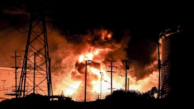 In this Tuesday, Oct. 17, 2017, photo provided by Jack Zellweger, a fire rages at the Chevron El Segundo Refinery in El Segundo, Calif. A fire that erupted at the West Coast's largest oil refinery threatened storage tanks and sent huge flames into the sky and black smoke across neighborhoods before crews quickly smothered it. Dozens of firefighters responded late Tuesday to the 1,000-acre refinery just south of Los Angeles, which processes nearly 275,000 gallons of crude per day.