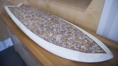 A surfboard that Taylor Lane, of Santa Cruz, Calif., made with 10,000 discarded cigarette butts for the annual “Creators & Innovators Upcycle Contest” at the Ecology Center in San Juan Capistrano, Calif. Lane, a California surfer, has won the recycled surfboard contest.