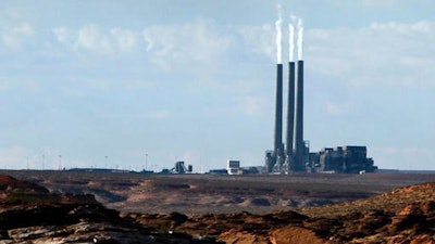 In this Sept. 4, 2011 file photo, smoke rises from the stacks of the main plant facility at the Navajo Generating Station, as seen from Lake Powell in Page, Ariz. The coal-fired power plant in far northern Arizona that was built to deliver water to the state's desert region is set to retire in 2019 unless a new owner can be found.
