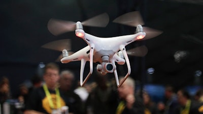 In this Jan. 5, 2017 file photo, an exhibitor demonstrates a drone flight at CES International, in Las Vegas. White House officials said Trump will sign a memorandum Wednesday permitting states, localities and tribes to craft their own pilot programs to test drones. There is no limit on the number of communities that can participate.