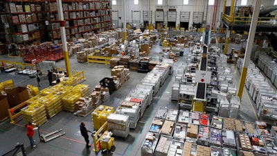 In this Aug. 3, 2017, photo, workers prepare to move products at an Amazon fulfillment center in Baltimore. While jobs have been lost in brick-and-mortar stores, many more have been gained from e-commerce and warehousing. Amazon accounts for much of the additional employment.