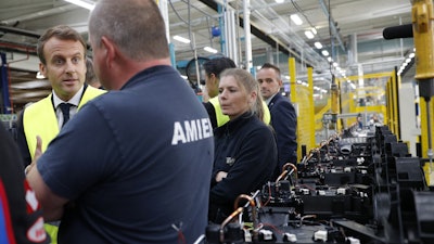 French President Emmanuel Macron talks with Whirlpool employees during a visit at the company's factory in Amiens, France, Tuesday, Oct. 3, 2017. Macron visits an ailing Whirlpool dryer factory in northern France that was the site of a pivotal moment in his presidential campaign, when he debated with angry workers about his strategy to stop job losses.