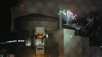 In this photo provided by Greenpeace France and dated Thursday, Oct. 12, 2017, Greenpeace activists set off fireworks inside the nuclear power plant of Cattenom, eastern France. Eight environmental activists are in custody after breaking into a French nuclear power station and setting off fireworks, in a bid to urge better protection for nuclear waste and protest France's dependence on atomic energy.