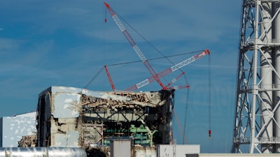 In this Nov. 12, 2011, the Unit 4 reactor building of the crippled Fukushima Dai-ichi nuclear power station is seen through a bus window in Okuma, Japan.