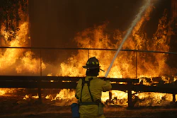In this Oct. 9, 2017 file photo, a firefighter sprays a hose into a Keysight Technologies building in Santa Rosa, Calif. The Santa Rosa Press Democrat reported that more than 100 boxes of letters and other materials from tech pioneers William Hewlett and David Packard burned in the fires. Electronics firm Keysight Technologies had acquired the archives through spinoffs, and the archives were stored at its offices in Santa Rosa.