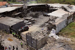 The damage of a fireworks factory is seen as police investigators inspect the site of an explosion and fire in Tangerang, on the outskirts of Jakarta, Indonesia, Friday, Oct. 27, 2017. Investigators Friday were trying to determine the cause of the fire that killed dozens of people, mostly young female workers unable to escape.