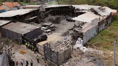 The damage of a fireworks factory is seen as police investigators inspect the site of an explosion and fire in Tangerang, on the outskirts of Jakarta, Indonesia, Friday, Oct. 27, 2017. Investigators Friday were trying to determine the cause of the fire that killed dozens of people, mostly young female workers unable to escape.