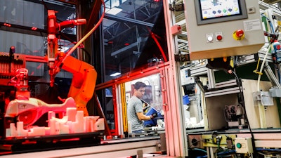 In this Thursday, May 25, 2017, file photo, an assembly line laborer works alongside a collaborative robot, left, on a chainsaw production line at the Stihl Inc. production plant in Virginia Beach, Va. On Tuesday, Oct. 17, 2017, the Federal Reserve reports on U.S. industrial production for September.